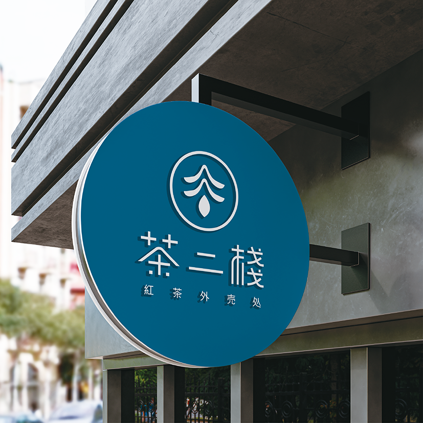 藍底白字圓形招牌，中央為抽象茶葉與水滴的極簡圖案，下方為品牌名稱『茶二棧』與文字『紅茶外賣處
