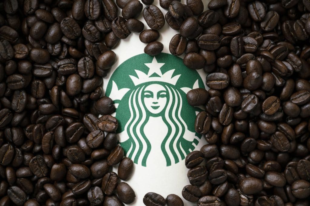 品牌識別-星巴克，一杯擁有星巴克品牌識別的杯子咖啡豆裡。