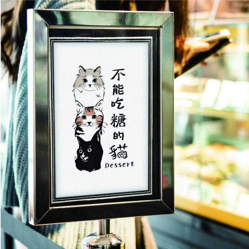 不能吃糖的貓在立牌上放上了LOGO設計的圖樣。